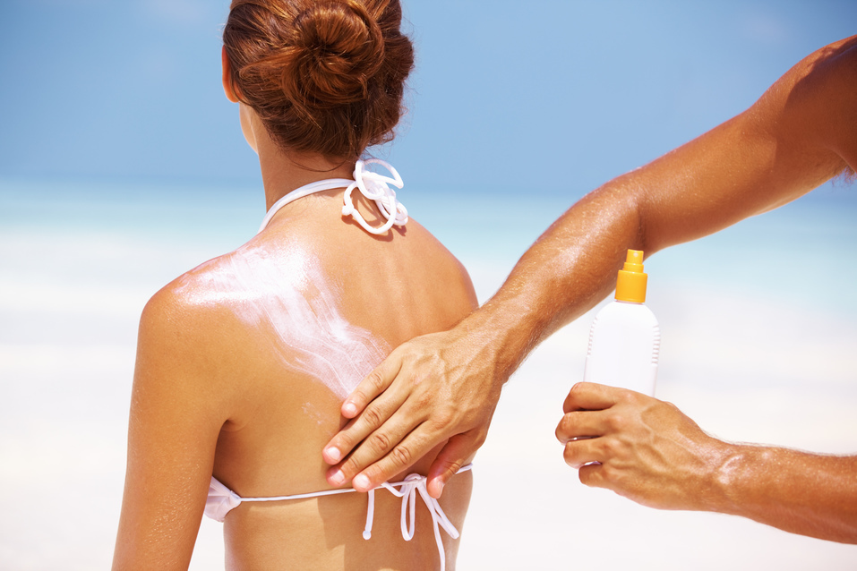 @Glowimages: Man applying sun block lotion on woman´s back